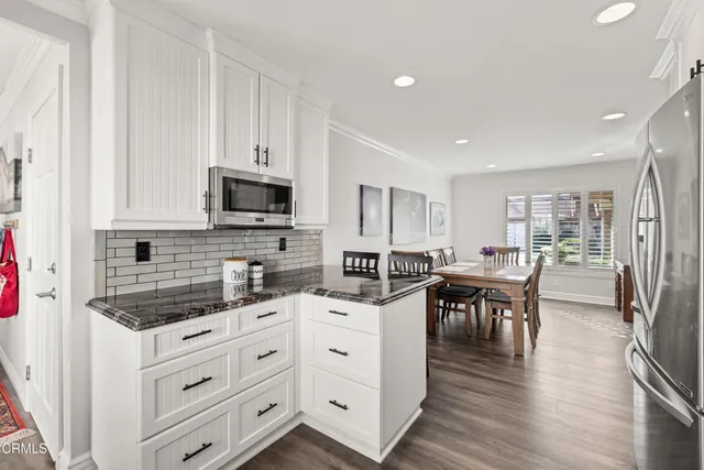 a kitchen with white cabinets and appliances
