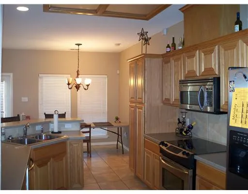 a kitchen with granite countertop a sink cabinets and appliances