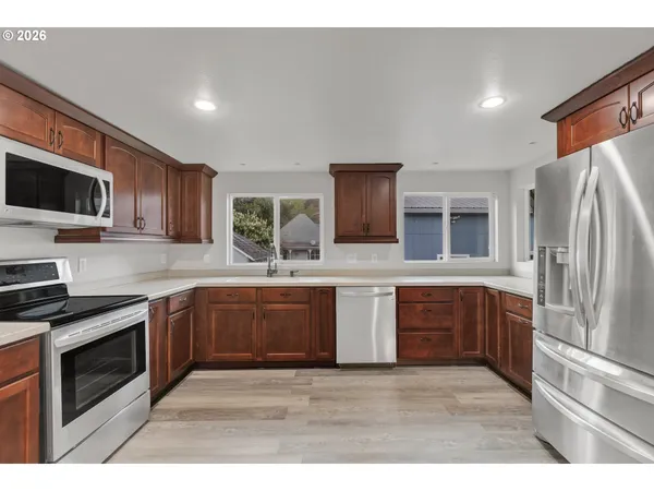 a kitchen with stainless steel appliances granite countertop a refrigerator stove microwave and sink
