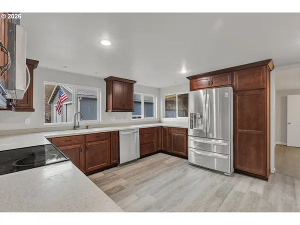a kitchen with stainless steel appliances kitchen island granite countertop a refrigerator stove and sink