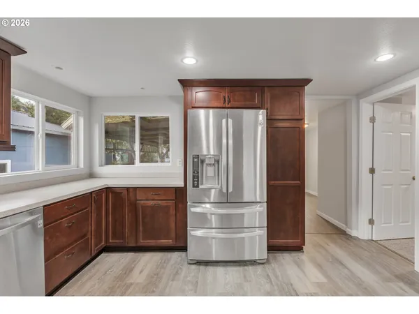 a kitchen with stainless steel appliances granite countertop a refrigerator and a sink