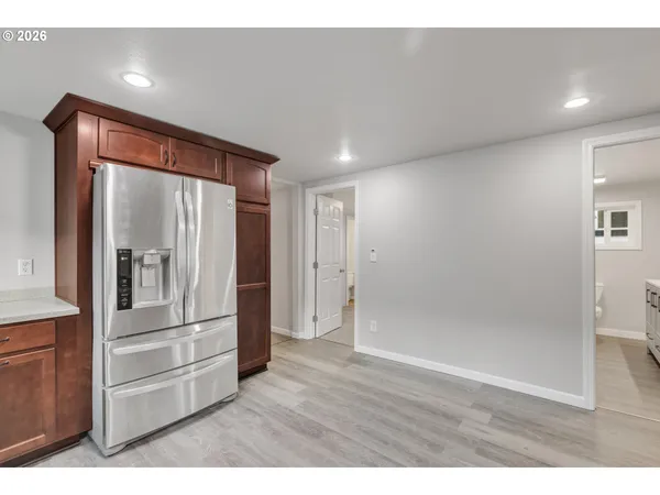a view of kitchen with refrigerator and cabinets