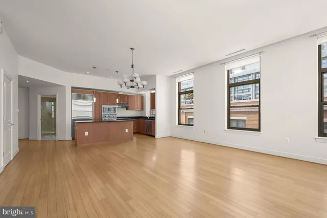 wooden floor in an empty room with a kitchen