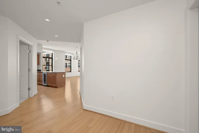 a view of a big room with wooden floor and a kitchen