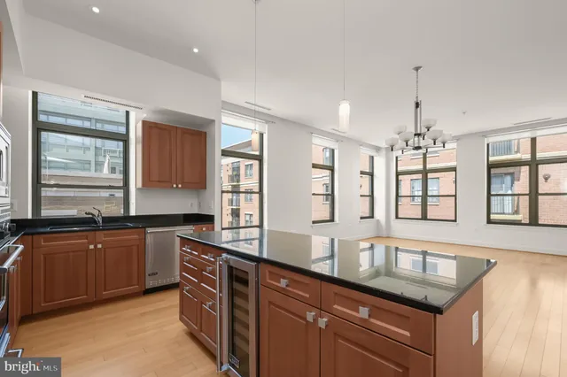 a kitchen with granite countertop cabinets a sink a window and stainless steel appliances