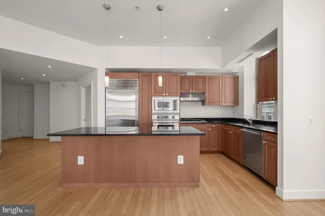a kitchen with stainless steel appliances granite countertop a stove a sink and a refrigerator