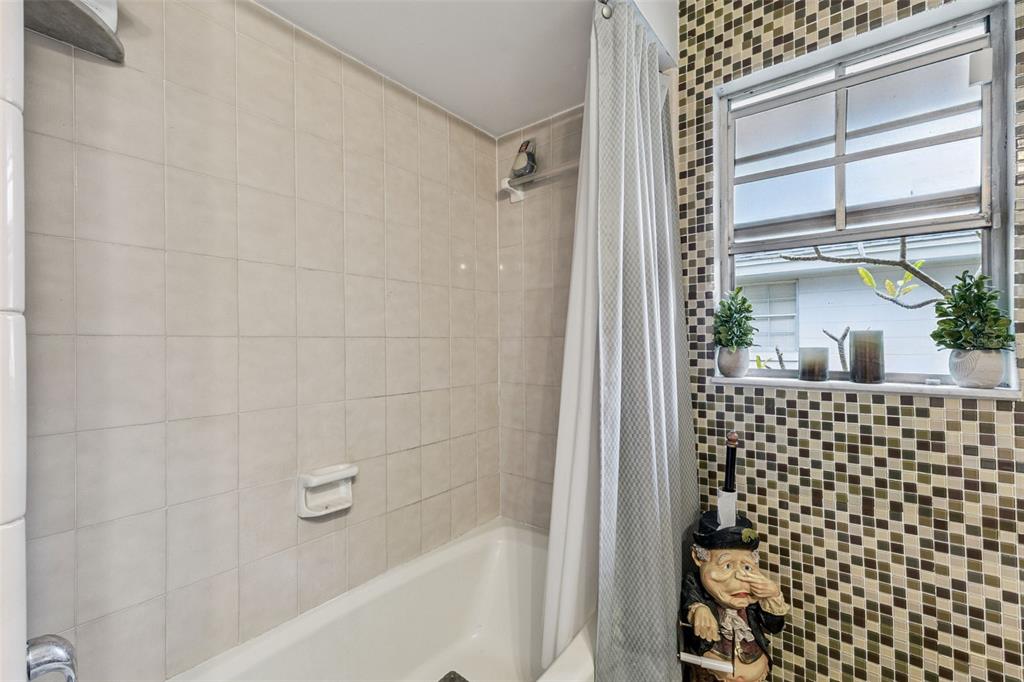 611 North Forsyth Road Orlando, FL 32807 - Photo 15 of 36 a bathroom with a shower curtain and a window