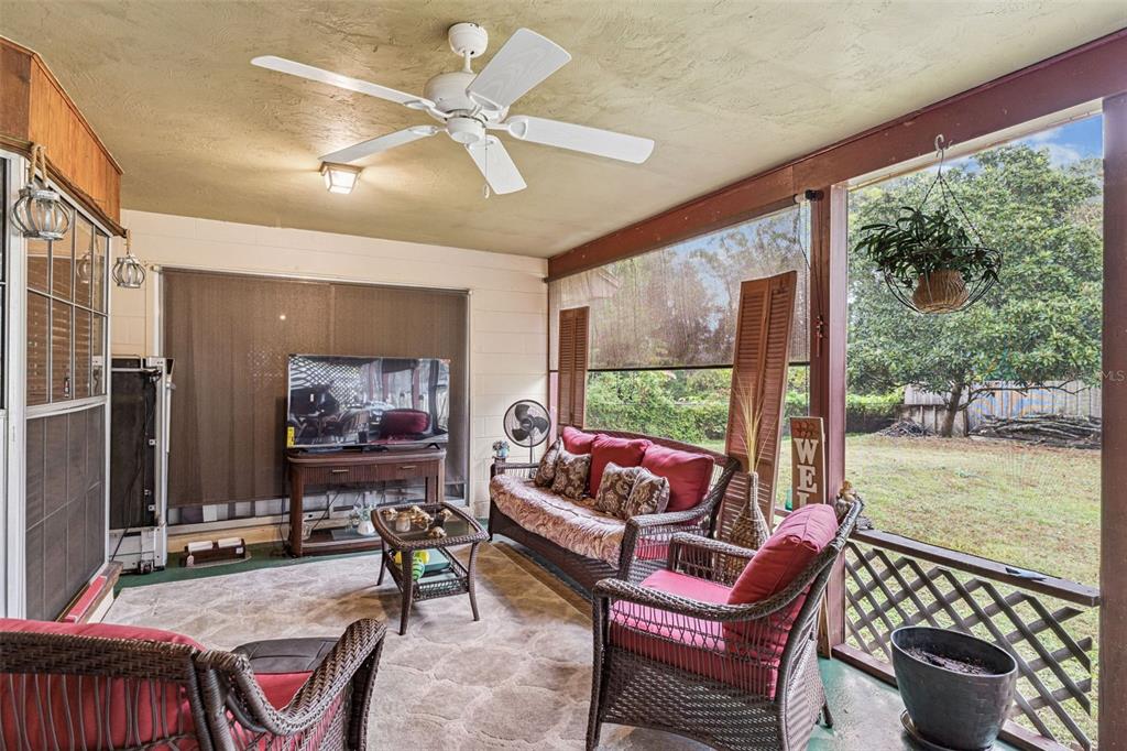 611 North Forsyth Road Orlando, FL 32807 - Photo 27 of 36 a living room with furniture a flat screen tv and a floor to ceiling window
