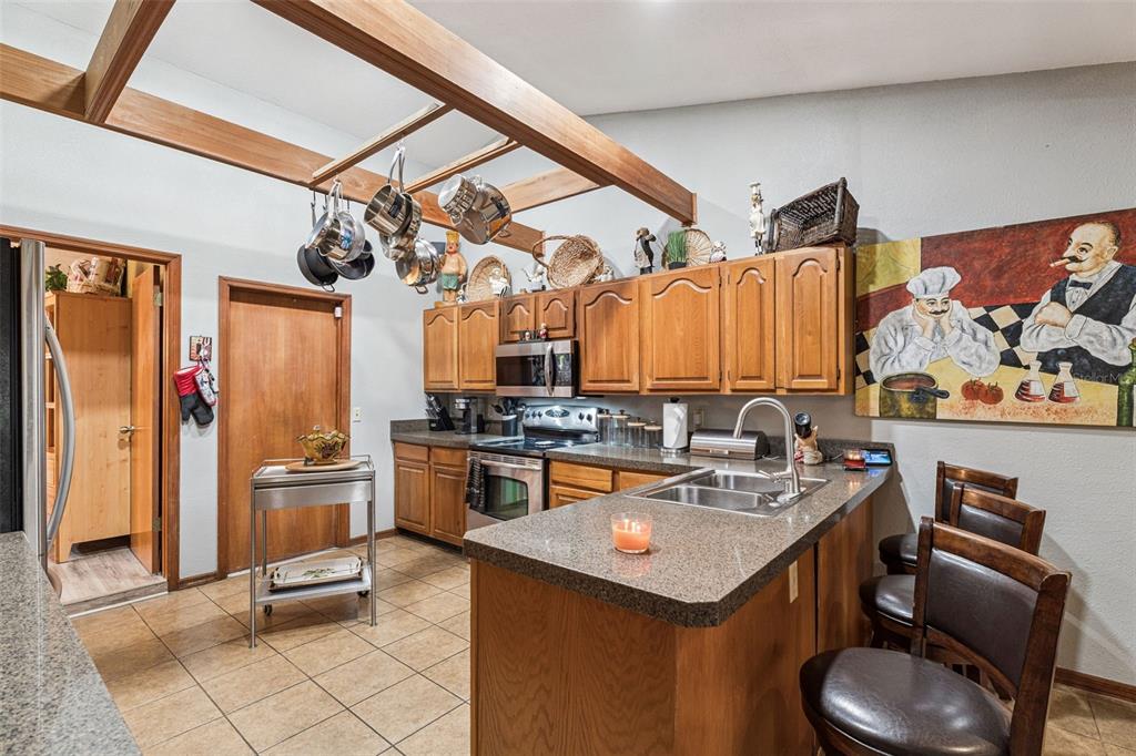 611 North Forsyth Road Orlando, FL 32807 - Photo 9 of 36 a kitchen with stainless steel appliances granite countertop a sink a stove and refrigerator