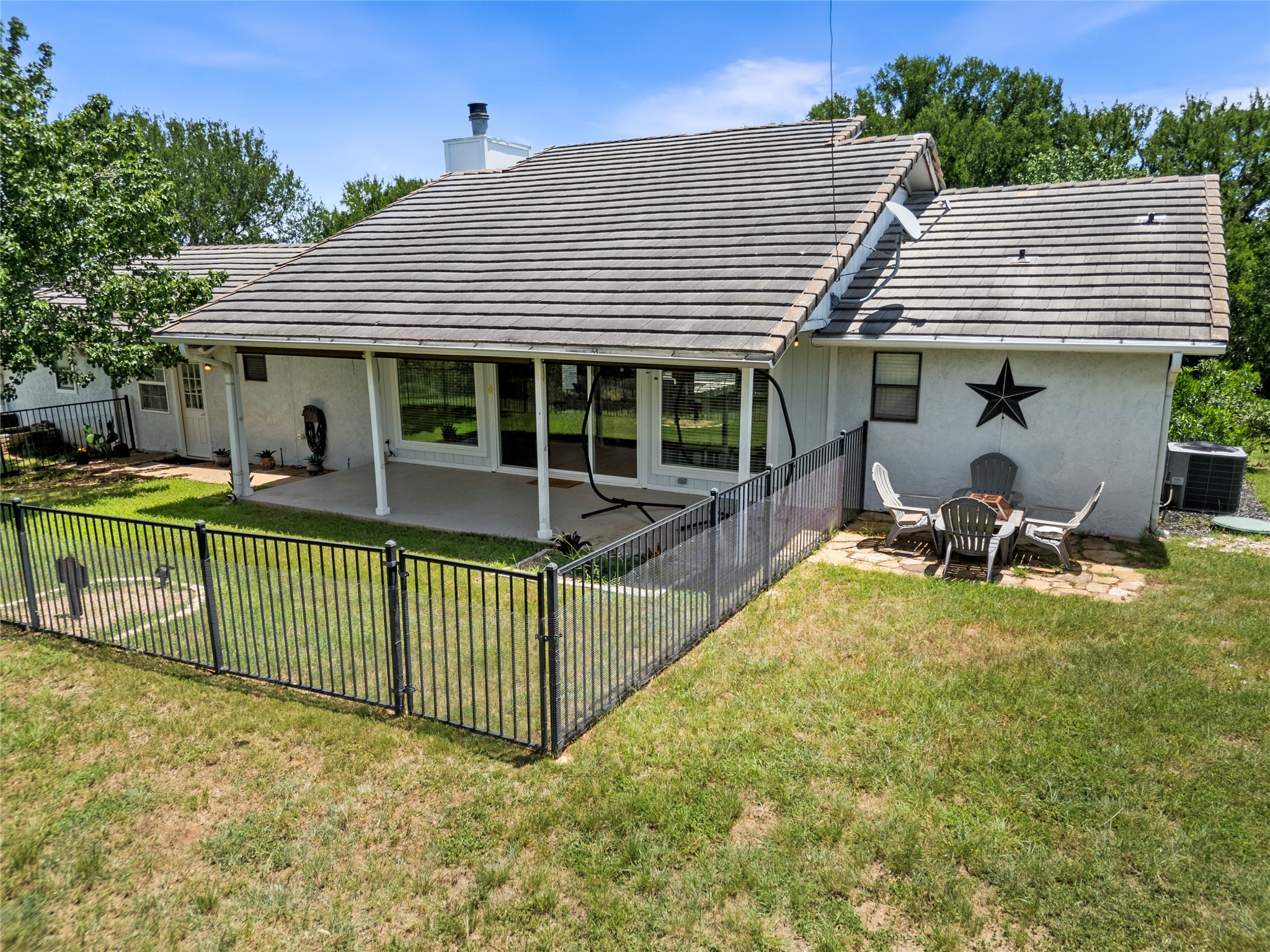 210 Teeoff, Unit B Horseshoe Bay, TX 78657 - Photo 30 of 38 A fenced backyard offers a serene retreat with a covered patio for outdoor enjoyment.