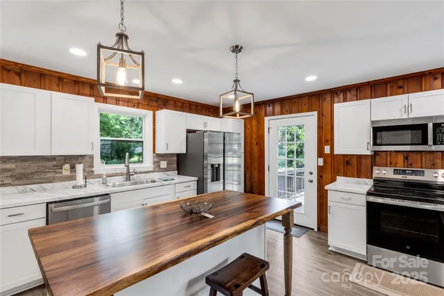 a kitchen with stainless steel appliances kitchen island granite countertop a stove and a sink