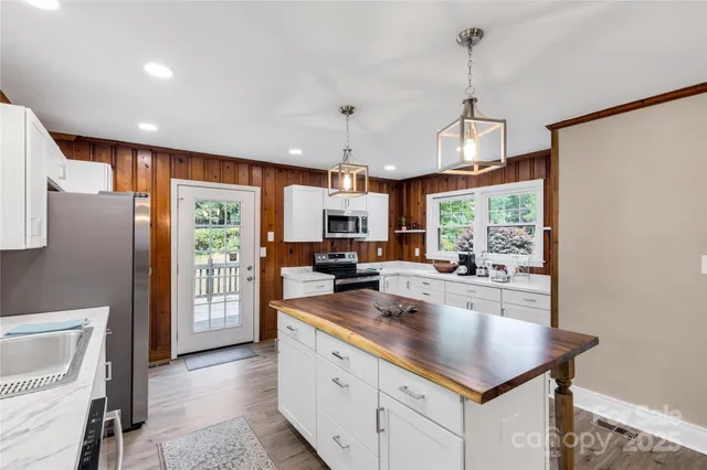 a kitchen with sink refrigerator and microwave