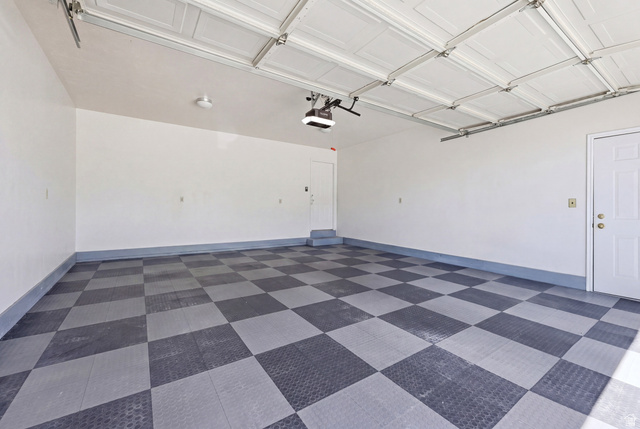 3766 Cardiff Circle Bountiful, UT 84010 - Photo 36 of 46 Spacious two-car garage featuring a checkerboard-patterned floor, white paneled garage door, and two white entry doors