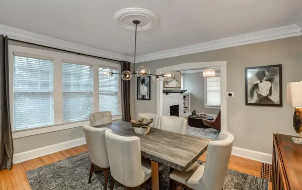 a dining room with furniture a chandelier and wooden floor