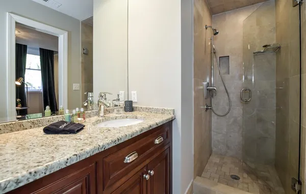a bathroom with a granite countertop sink and a mirror