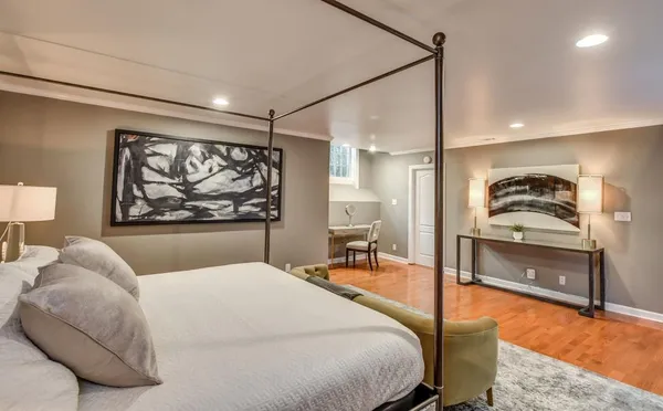 a bedroom with a bed and a painting on the wall