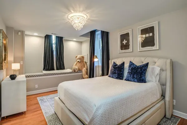 a spacious bedroom with a large bed and a chandelier