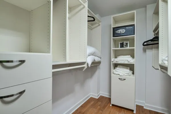 a view of walk in closet with clothes and shoes
