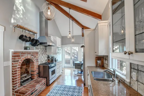 a kitchen with stainless steel appliances granite countertop a refrigerator a stove and a wooden floors