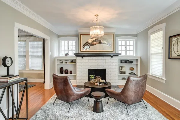 a living room with furniture a fireplace and windows