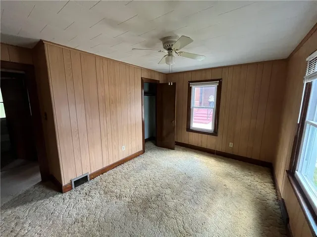 an empty room with windows and cabinet