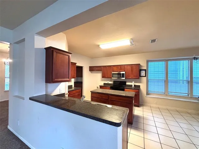 a kitchen with stainless steel appliances granite countertop a sink and a stove