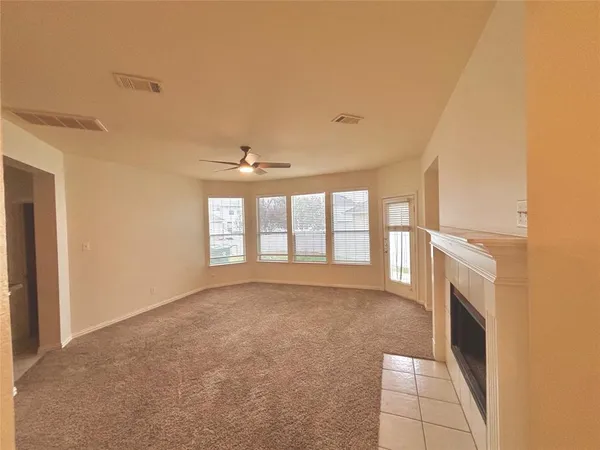 a view of an empty room with a fireplace and a window