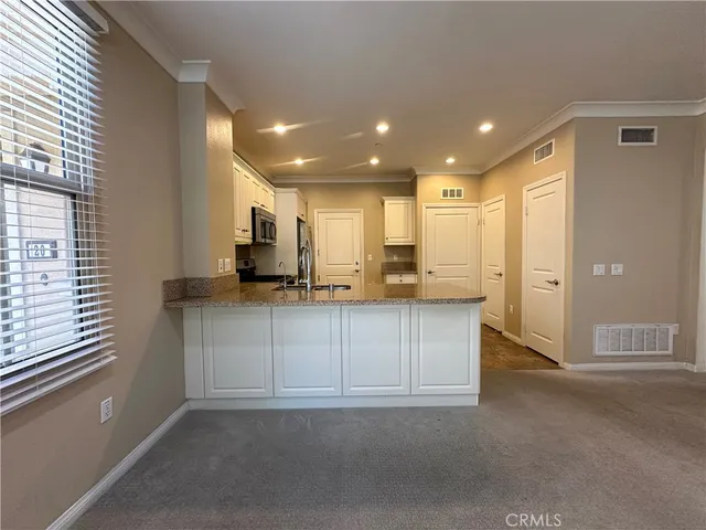 a view of kitchen with stainless steel appliances cabinets