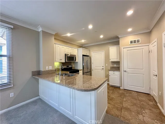 a kitchen with stainless steel appliances granite countertop a refrigerator and a sink