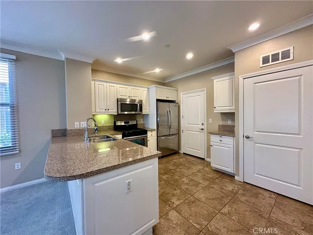 a kitchen with refrigerator and cabinets