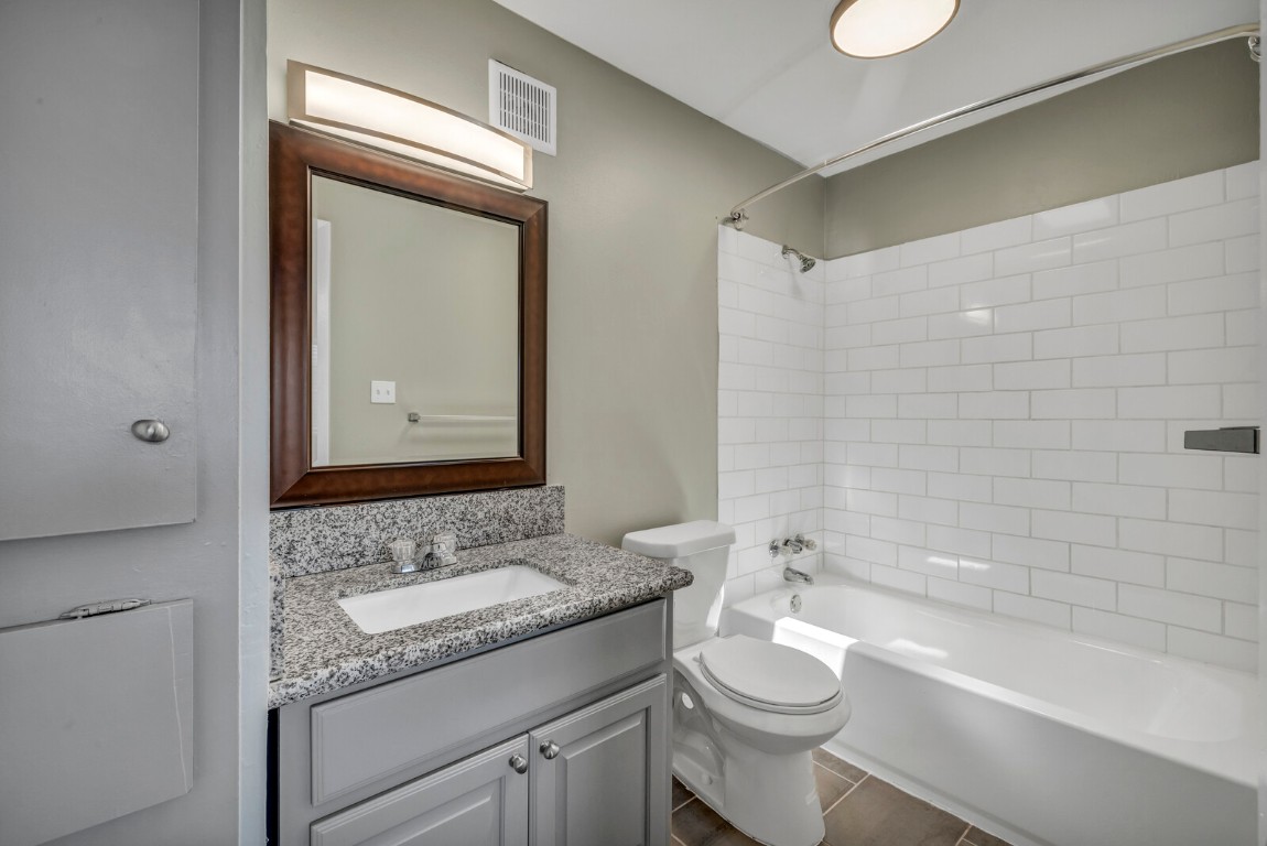 2808 Skyway Circle, Unit 101 Austin, TX 78704 - Photo 12 of 25 a bathroom with a granite countertop sink toilet mirror and bathtub
