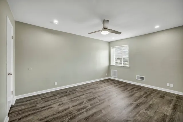 an empty room with a window and ceiling fan