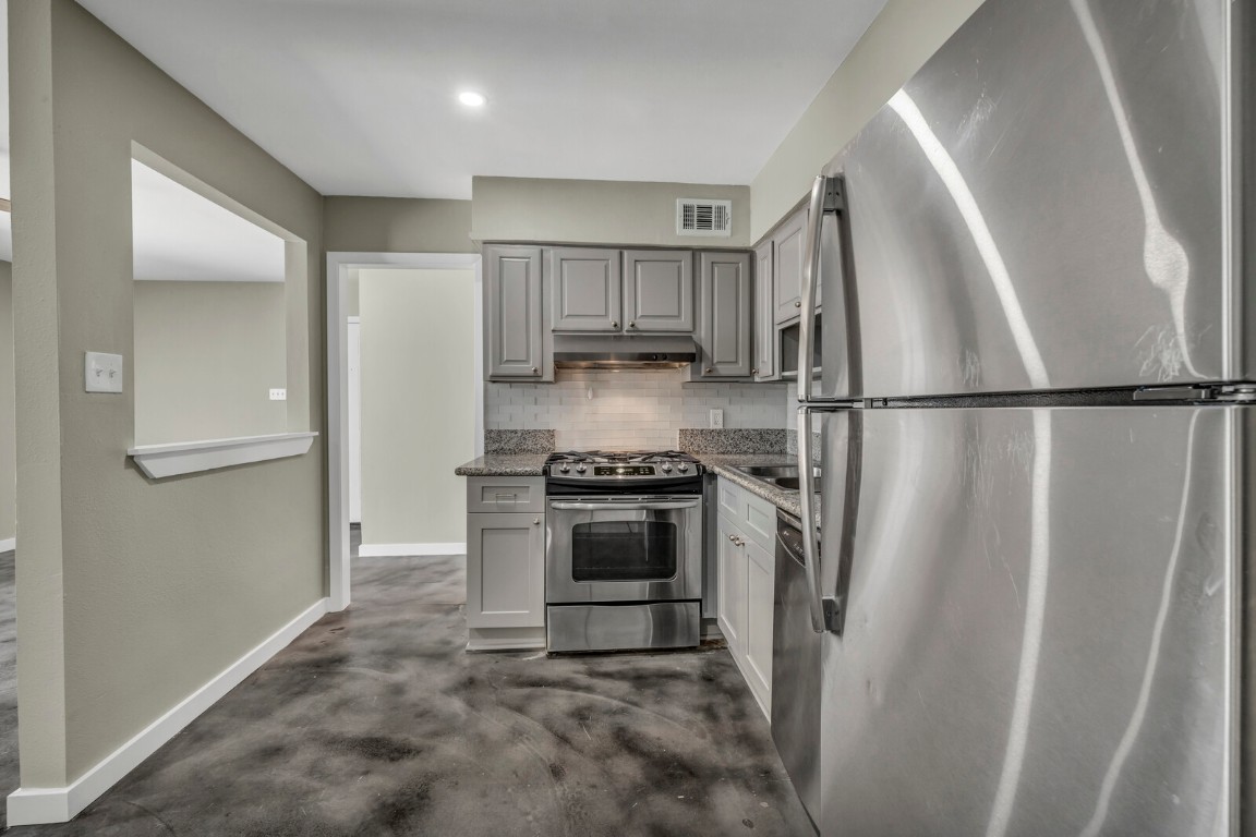 2808 Skyway Circle, Unit 101 Austin, TX 78704 - Photo 4 of 25 a kitchen with a refrigerator a stove top oven and cabinets