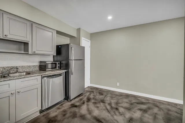a kitchen with granite countertop white cabinets and stainless steel appliances