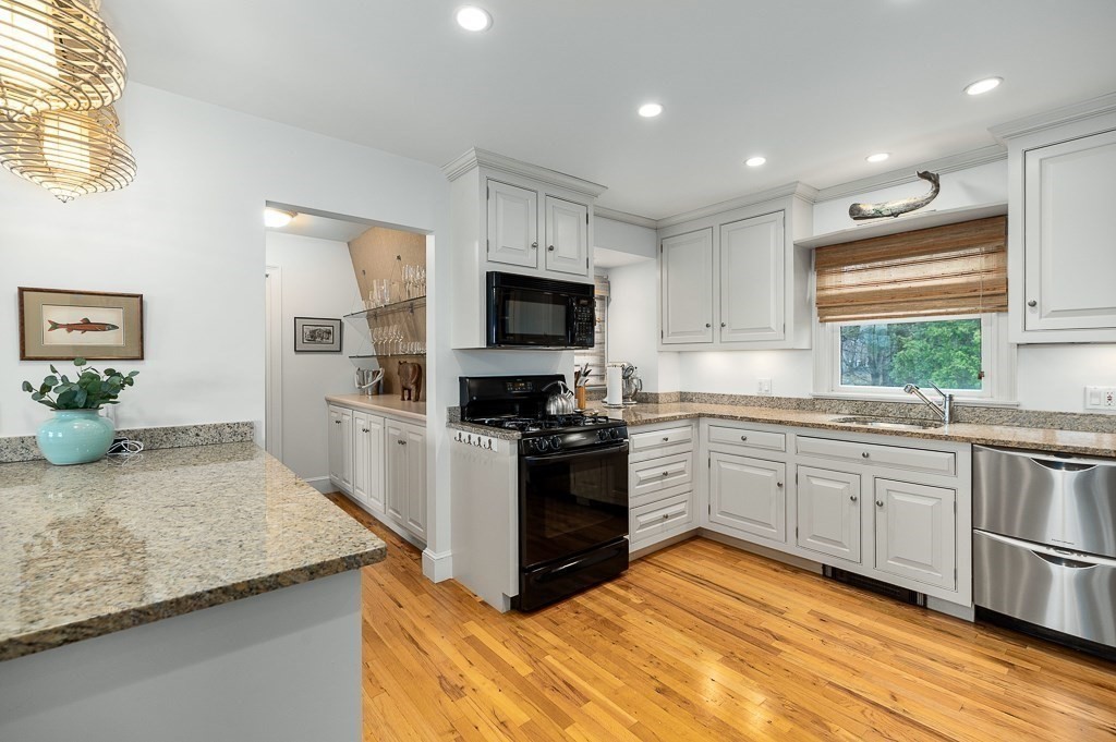 7 Hawthorne Lane Gloucester, MA 01930 - Photo 12 of 24 a large kitchen with granite countertop a stove top oven a sink a dining table and chairs