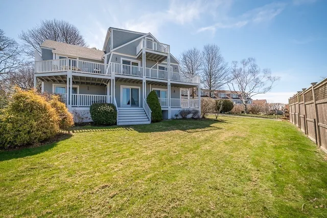 a front view of house with yard and trees in the background