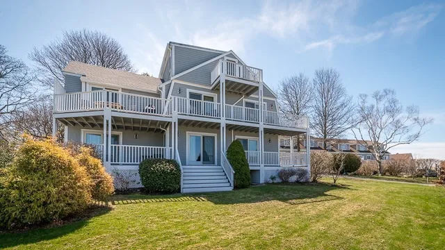 a view of a house with a yard and lawn chairs