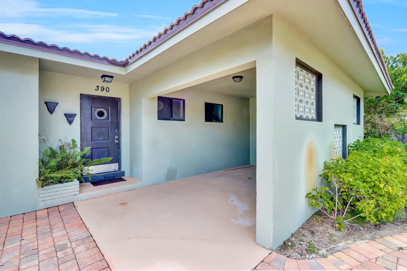 390 North Juno Lane Juno Beach, FL 33408 - Photo 15 of 33 a front view of a house with garden
