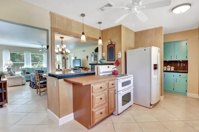 a kitchen with a refrigerator a sink dishwasher a oven with a dining table and chairs