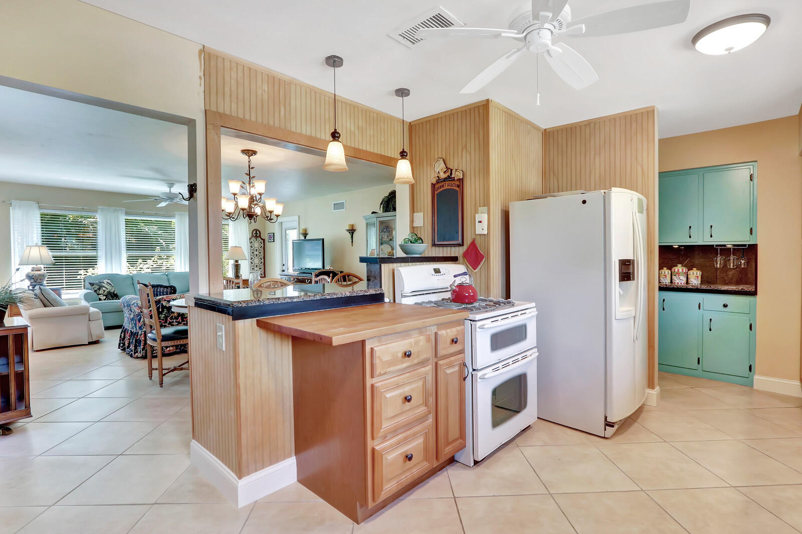 390 North Juno Lane Juno Beach, FL 33408 - Photo 26 of 33 a kitchen with a refrigerator a sink dishwasher a oven with a dining table and chairs
