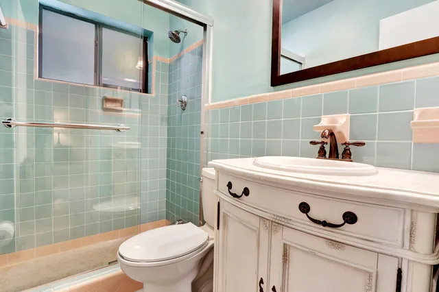 a bathroom with a sink a toilet and shower