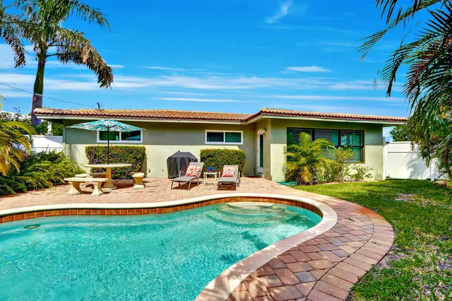 a view of a house with backyard sitting area and garden