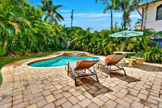 a swimming pool with outdoor seating and plants