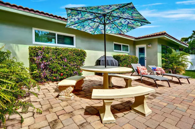 a view of a backyard with table and chairs under an umbrella
