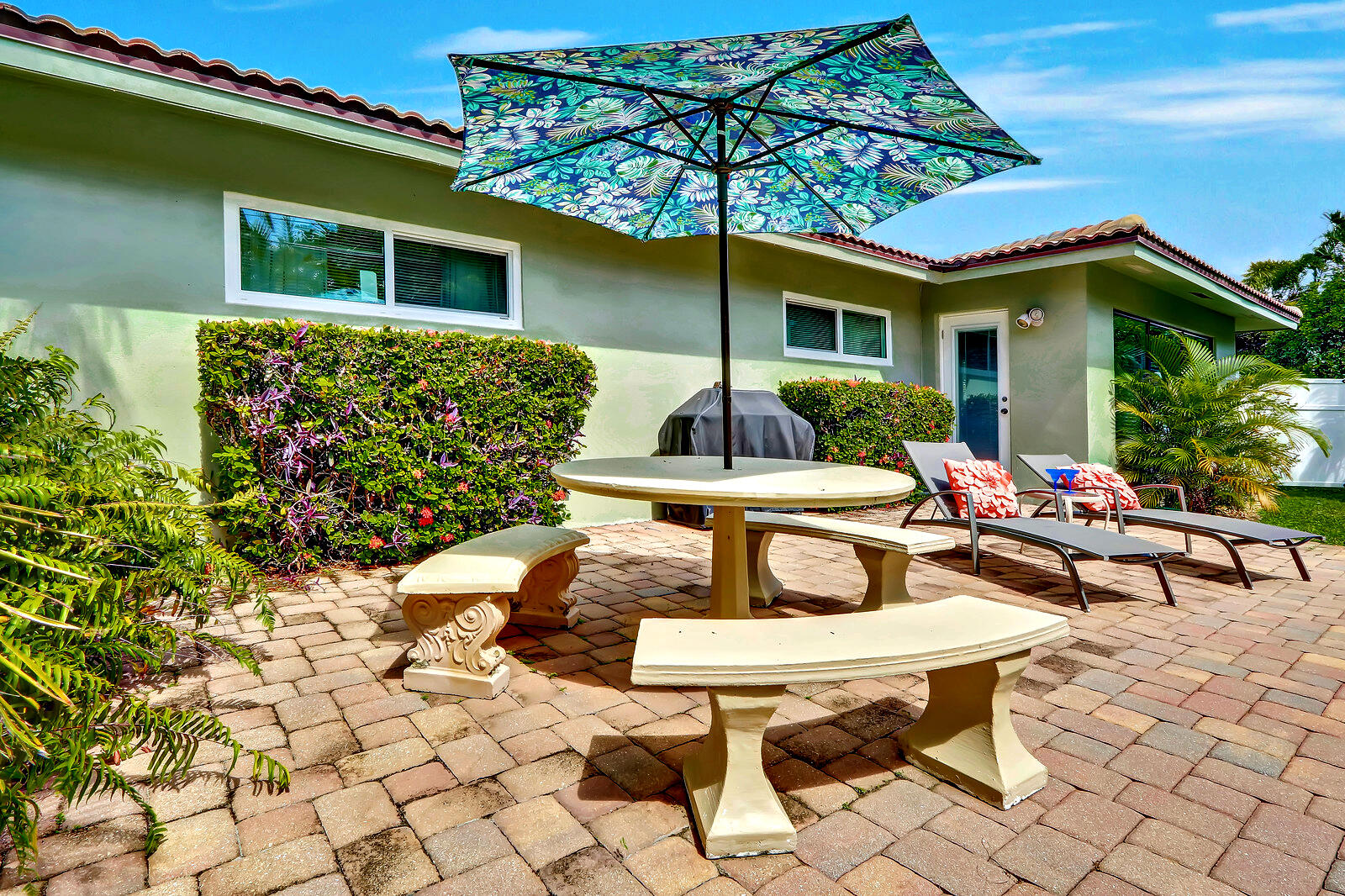 390 North Juno Lane Juno Beach, FL 33408 - Photo 10 of 33 a view of a backyard with table and chairs under an umbrella