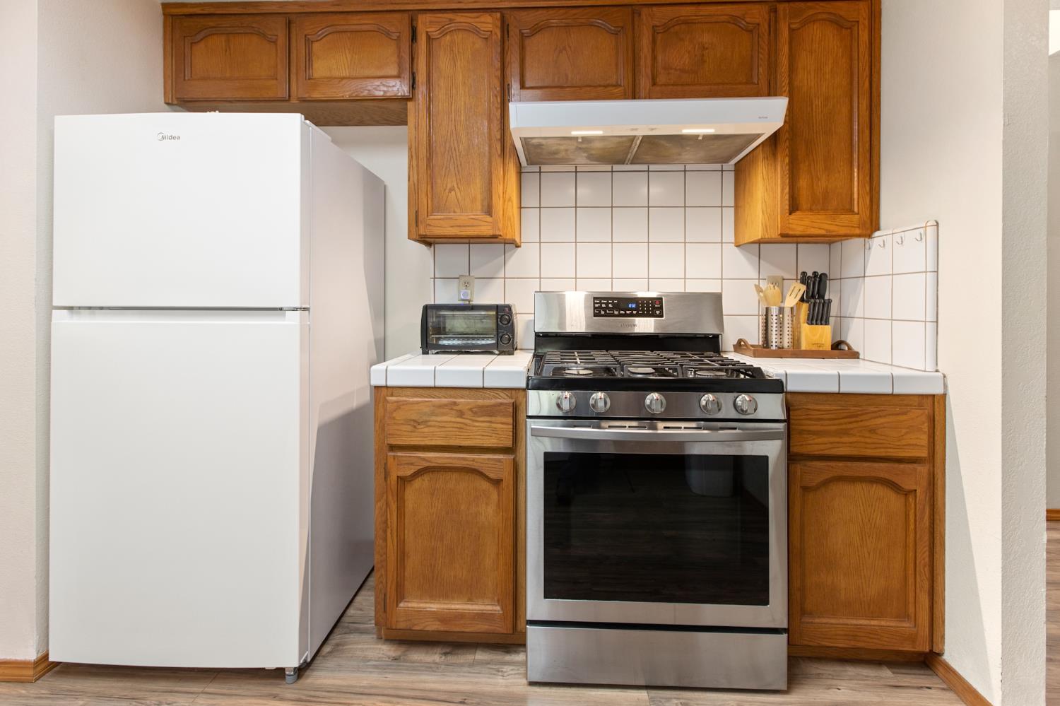 52865 Highway 245 Miramonte, CA 93641 - Photo 12 of 50 a kitchen with a refrigerator sink stove and cabinets