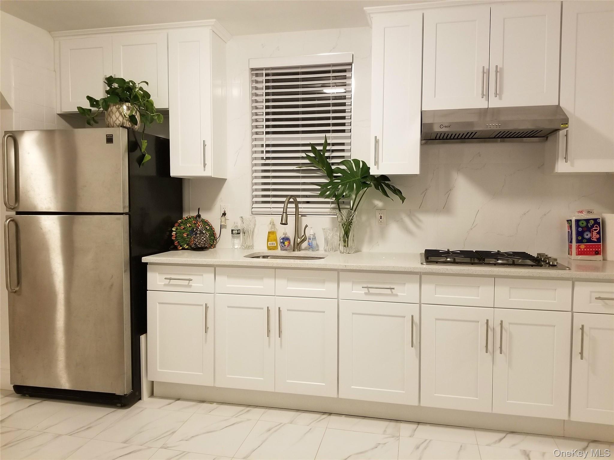 37-54 99th Street Queens, NY 11368 - Photo 11 of 18 a kitchen with white cabinets and refrigerator