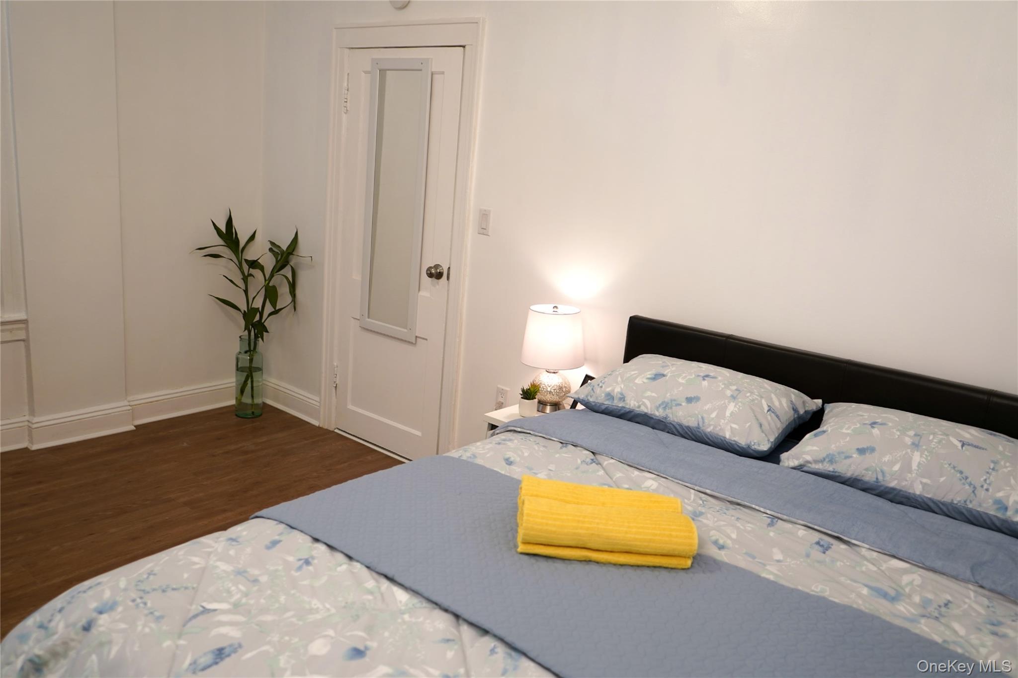 37-54 99th Street Queens, NY 11368 - Photo 13 of 18 a bedroom with a bed and a potted plant