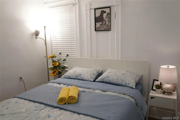 a bedroom with a bed and painting on the wall
