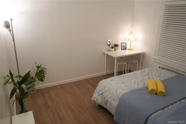 a bedroom with a bed and a potted plant